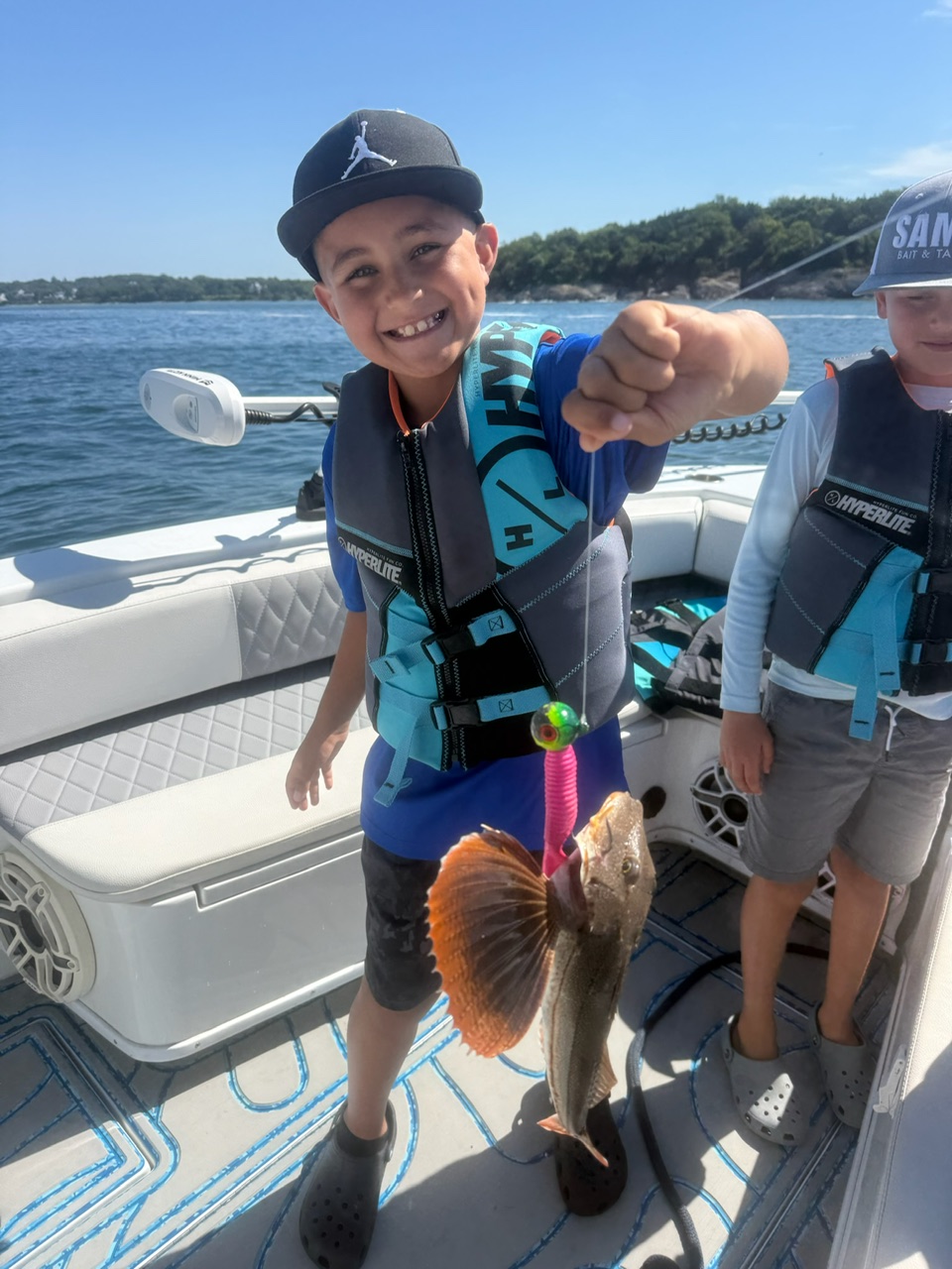 Academy camper holding up a sea robin caught on a pink jig