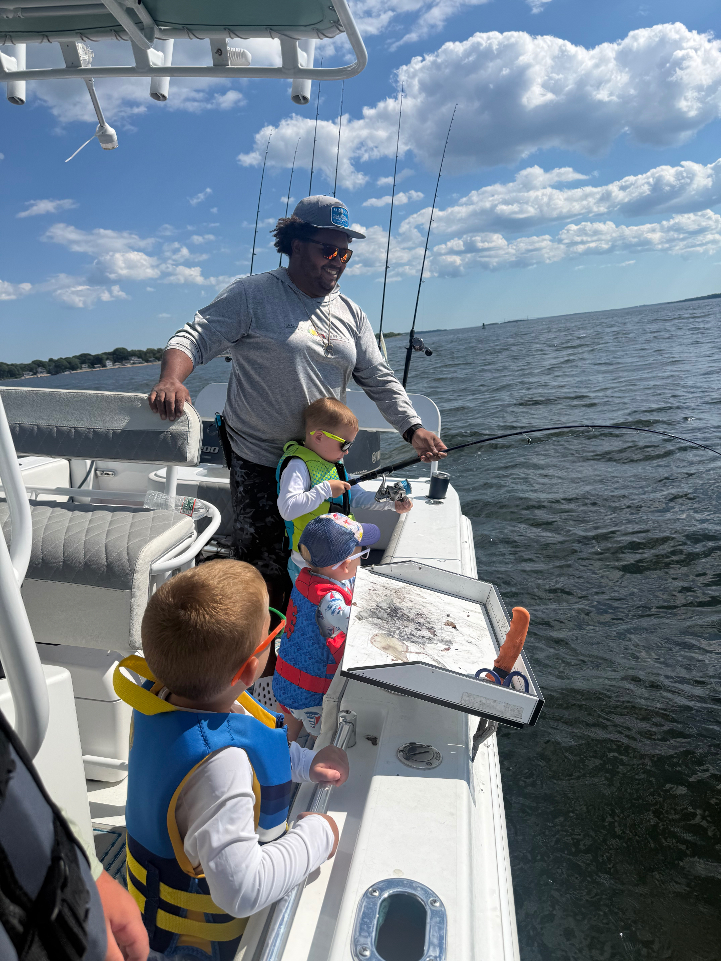 Captain Justen helping a young angler reel in a fish