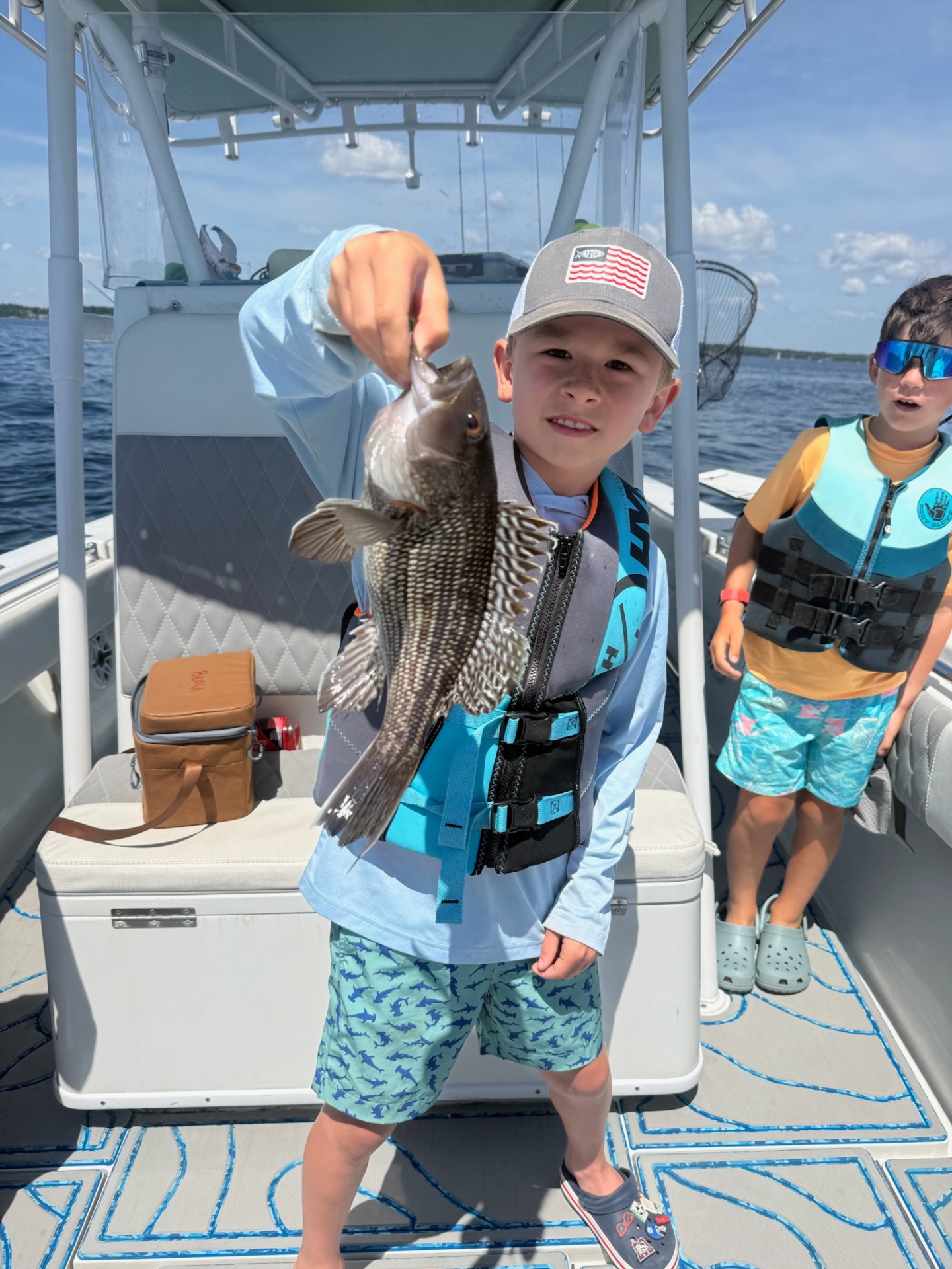 Academy camper holding up a black sea bass on the bay