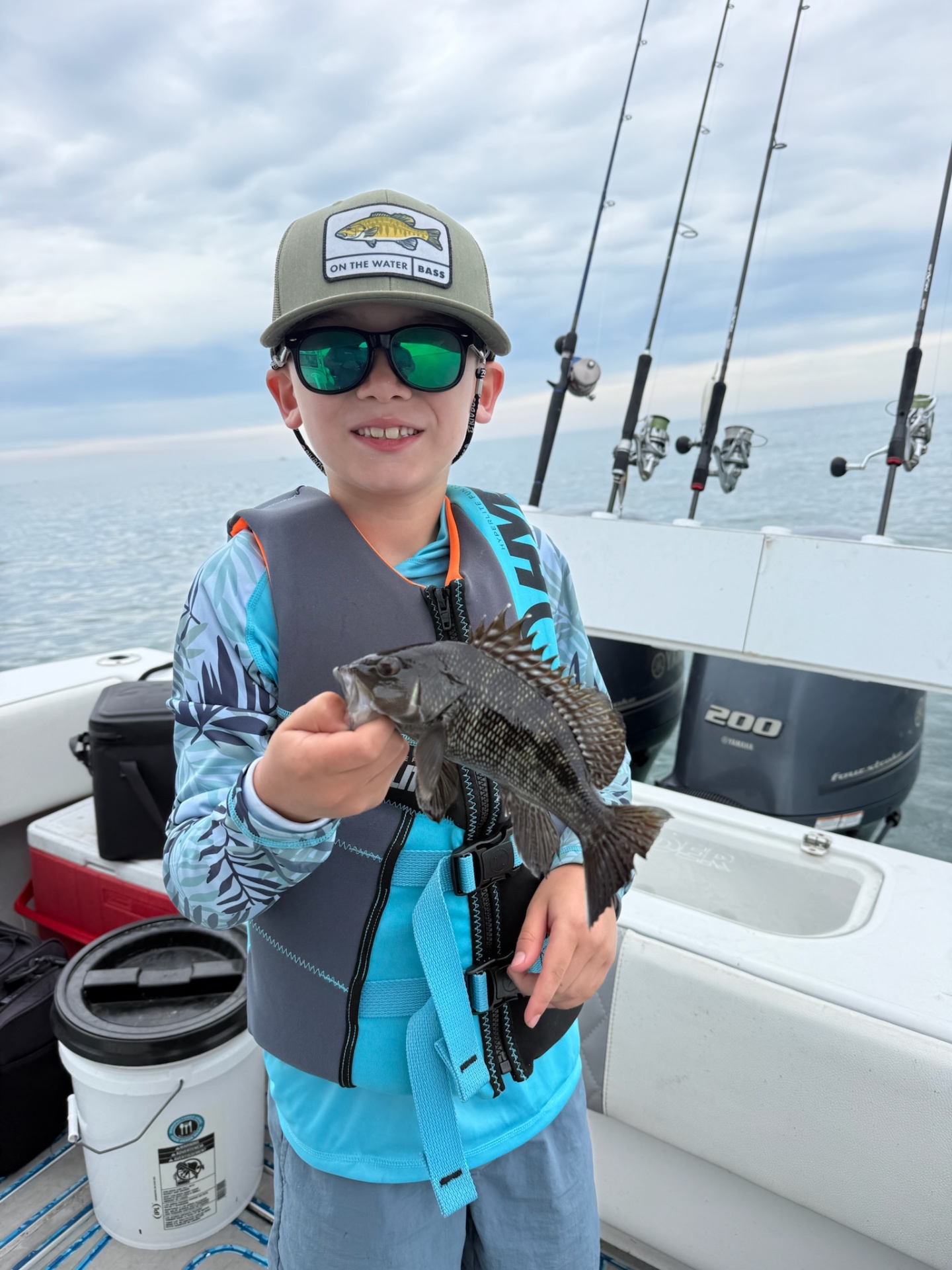 Academy camper in shades holding a black sea bass