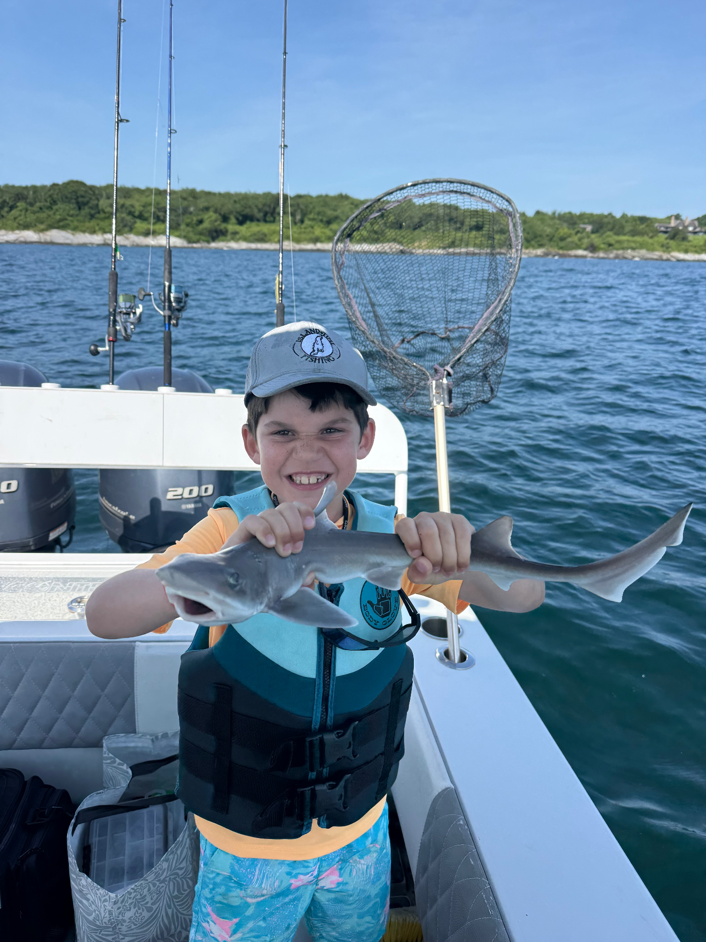 Academy camper smiling with a smooth dogfish on the bay
